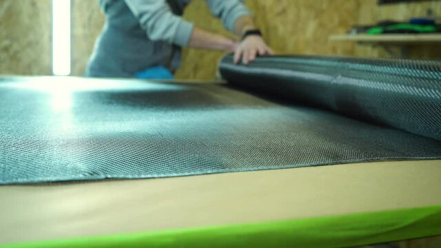 A roll of carbon fiber is spread on a table