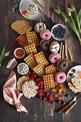 Flat layot from  festive dessert table with various of waffles, cake, muffins and sweets.
