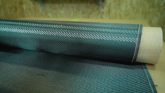 A roll of carbon fiber is spread on a table