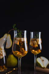 Pear drink in a glass goblet on a black background. Food styling. Menu design. Copy space