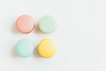 Sweet almond colorful pastel pink blue yellow green macaron or macaroon dessert cake isolated on white background. French sweet cookie. Minimal food bakery concept. Flat lay top view, copy space