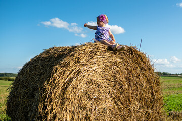 Naklejka na ściany i meble little child on a haystack