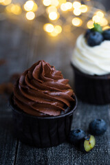 Cupcakes or muffins with chocolate cream and sweets. Cake celebration, delicious dessert, close-up