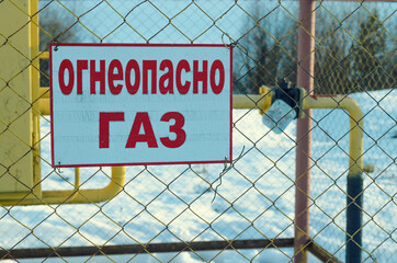 Naklejka premium Warning sign on the fence of a metal mesh 