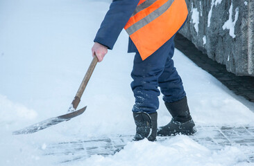 Workers remove snow from the sidewalks. Russian Winter. Snow removal.