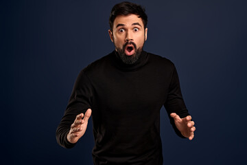Isolated shot of amazed surprised man looks with terror and panic, being shocked to hear bad news,...