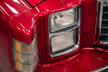 headlights of a retro car in red in the showroom. reconstruction