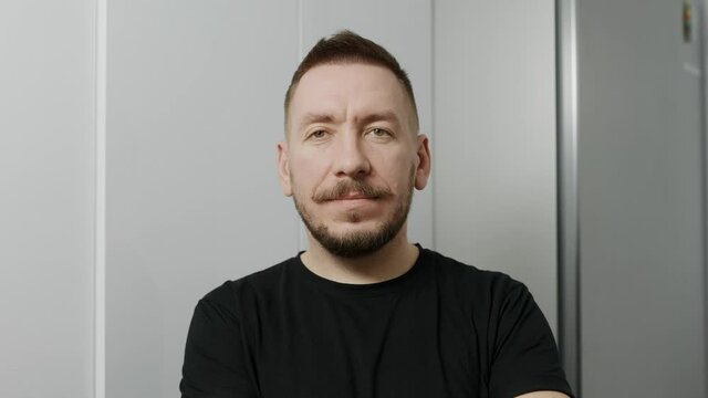 Portrait of a young man. The guy looks at the camera and smiles affably.