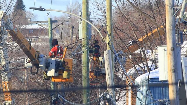 les employ&eacute;s travaillent sur un poteau &eacute;lectrique de la ville