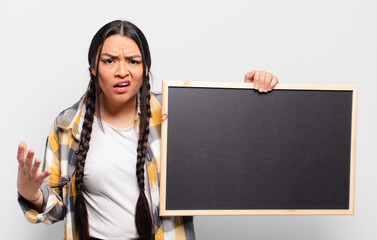 hispanic woman looking angry, annoyed and frustrated screaming wtf or what’s wrong with you