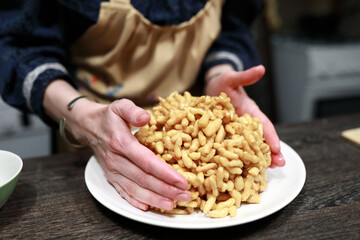 Woman forms chak-chak on plate