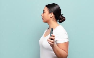 hispanic woman on profile view looking to copy space ahead, thinking, imagining or daydreaming