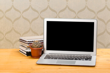 Fototapeta premium Notebook with notebooks and green succulent on a wooden table. mockup for text
