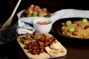 Food spanish crumbs with sausages, bacon, pomegranate and grapes
