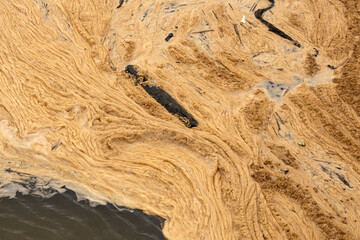 Dirty polluted foam on water
