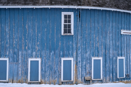 Blue Doors And Windows On The Side Of A Rustic Round Barn