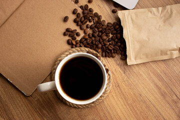 coffee mug, coffee beans, notebook, book on the wooden table for to do list nothing concept in cafe; top view. Coffee mug selective focusing for coffee shop vintage background . space for text.