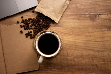 coffee mug, coffee beans, notebook, book on the wooden table for to do list nothing concept in cafe; top view. Coffee mug selective focusing for coffee shop vintage background . space for text.