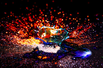 Drops of water colliding with powdered dye to create a multi coloured abstract droplet collision