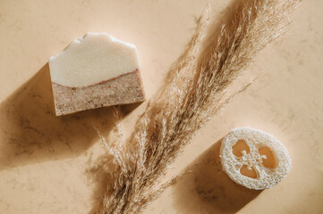 Handmade soap and pampas grass. Sunshade shadow on beige background. Zero waste, eco friendly cosmetics concept. Vintage color filter