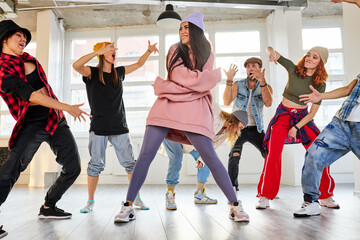 dancers having a rehearsal together, performing street dance or hip-hop movements. rnb