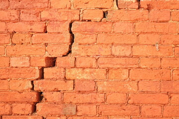 Cracked Red Brick Wall With Big Crack Structure. Damaged Brickwork Surface Texture. Destroyed And Aged Old Bricklaying Rift Material.
