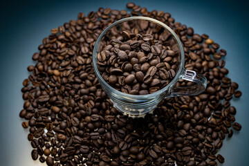 
a cup of coffee among roasted coffee beans