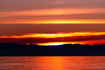 A dramatic sunset from the shores of Puget Sound at Deception Pass