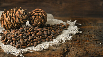 Fototapeta na wymiar pine nuts lie on a linen cloth, pine nuts lie on an old wooden board on the back side view