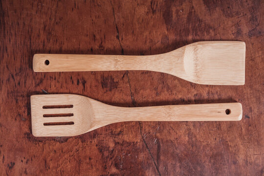Detail photo of bamboo kitchen utensils and shovels, on a wooden background. 