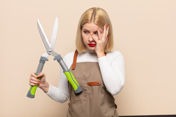 blonde woman feeling bored, frustrated and sleepy after a tiresome, dull and tedious task, holding...