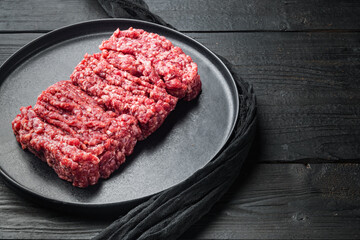 Raw minced meat, on black wooden table background  with copy space for text