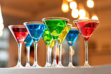 Variation alcoholic drinks served on bar counter. Colored drinks in glasses.