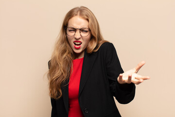 blonde woman looking angry, annoyed and frustrated screaming wtf or what’s wrong with you