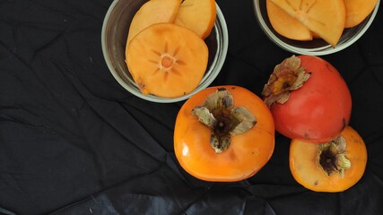 whole Persimmons  and fruit slices bowls