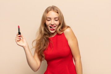 blonde woman with cheerful, carefree, rebellious attitude, joking and sticking tongue out, having...