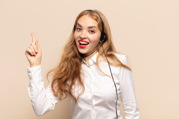 blonde woman feeling like a happy and excited genius after realizing an idea, cheerfully raising...