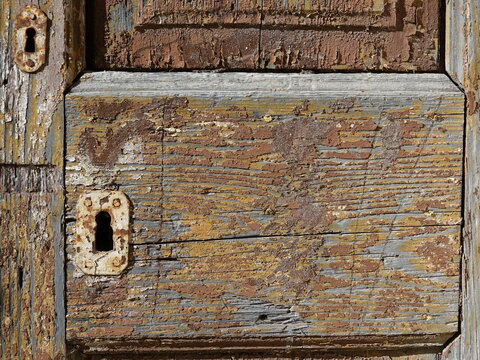Antique locks in a door with cracked paint