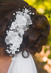 Fototapeta na wymiar Wedding hairstyle bride brunette with white roses decoration, close-up