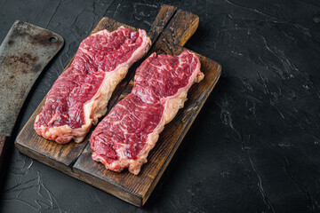 Two classic fresh beef steaks, on black background