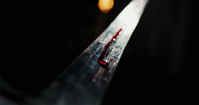 Sword with blood against the background of night and bright light that shimmers along the blade and creates the effect of killing the hero of a knightly battle in the Middle Ages.