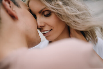 Beautiful couple in smart casual smiling close to each other want to passionately kiss. Portrait of a couple close up