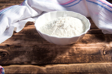 Oat flour  on dark wooden background.
