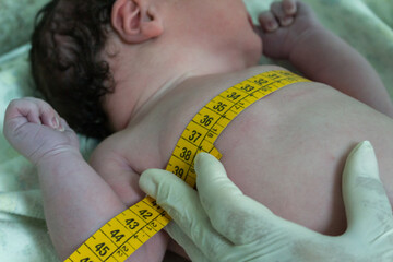 The first care of a newborn child. Measurement of the thorax diameter.