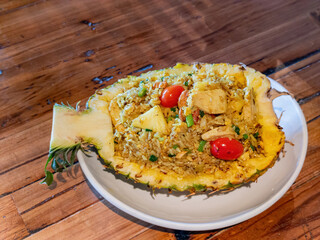 Close up shot of chicken and tomato, fried rice filled in a pineapple