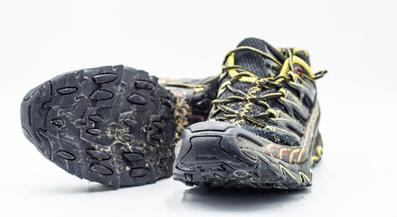 Dirty trail running shoes over white background