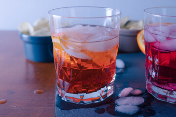 Two spritz with some chips on the table ready for the aperitif, the orangeone is mixed with Aperol. One sprtiz is mixed with aperol and one with campari. High quality photo