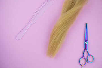 Professional hair dresser tools with copy space on trendy pink background. Stylist equipment set. Scissors and hair curls flat lay top view.