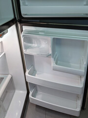empty, modern refrigerator with opened doors. Inside of a clean fridge with plastic shelves