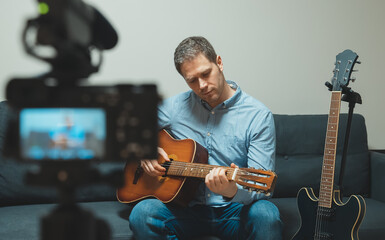 Obraz premium Man with spanish guitar in front of the video camera.